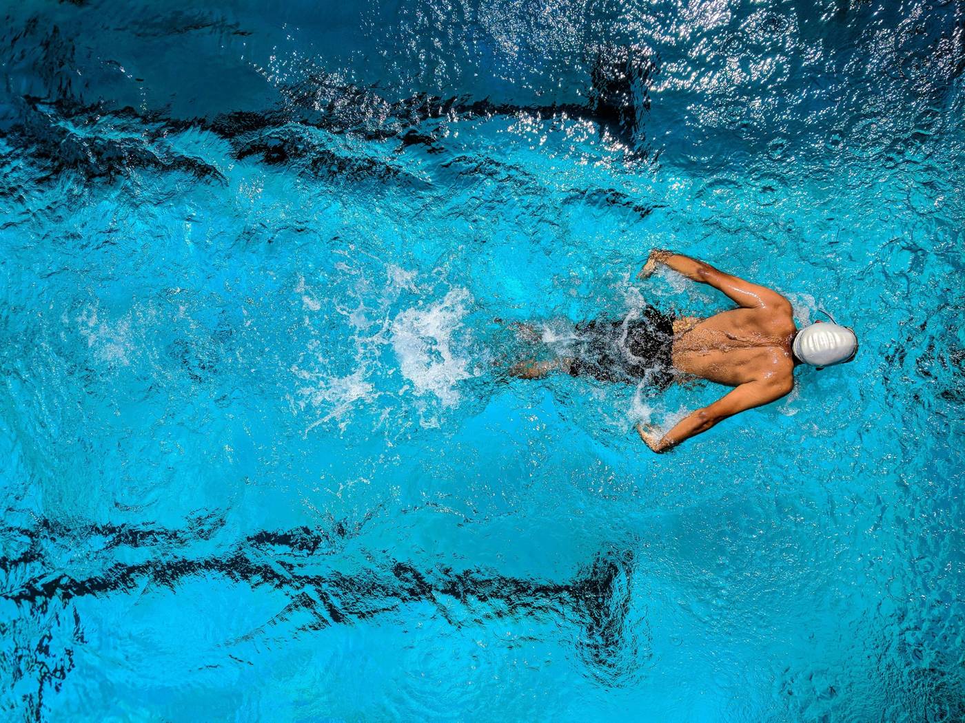 Nadador de resistencia compitiendo en piscina – energía sostenida con Kronos Endurance